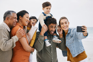 Happy family, grandparents and selfie on beach for kids holiday, vacation and outdoor on social media. Mother, father and senior people with interracial children in profile picture by the ocean