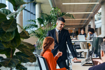 In a contemporary startup office a modern businesswoman with orange hair engages in a discussion...