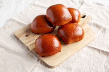 Homemade Pirozhki with Potato and Bacon on a wooden board, side view.
