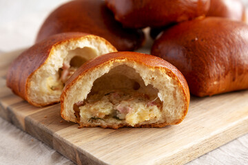 Homemade Pirozhki with Potato and Bacon on a wooden board, side view.
