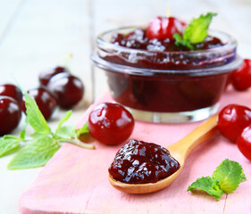 cherry jam in a jar and fresh berries on the table