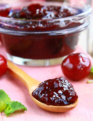 cherry jam in a jar and fresh berries on the table