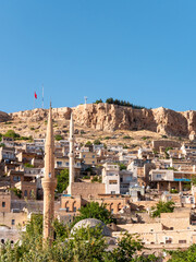 Cityscape of the old city of Mardin, Turkey featuring a hill, traditionnal stone houses and mosques - Portrait shot 3