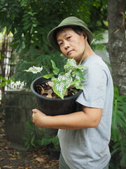 gardenner with colorfull plants in hand and green garden backgrouns happy smile 