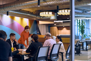 A diverse team of business experts in a modern glass office, attentively listening to a colleague's presentation, fostering collaboration and innovation.