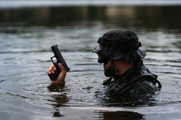 Combat swimmer, marine with a pistol in his hand at sea.