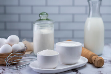 mise en place sugar ingredients coconut flour milk whisk and kneading stick and eggs with white batter