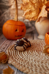 Autumn decorations with Halloween spider cookies near traditional Jack o lantern