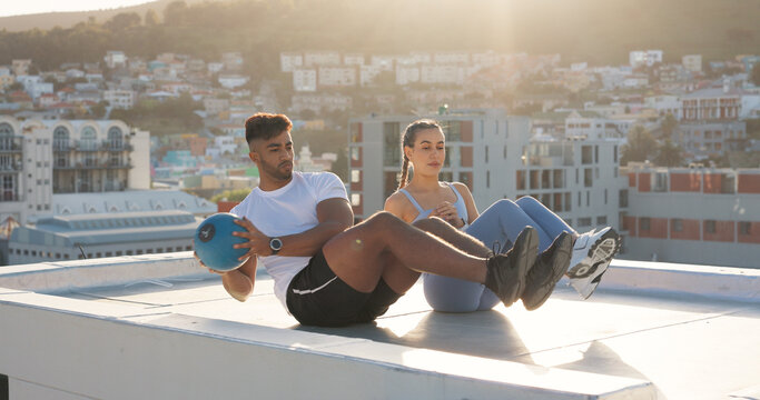 Health, medicine ball and fitness with couple in city for training, sports and support. Wellness, workout and exercise with man and woman on rooftop for challenge, teamwork and motivation together - Powered by Adobe