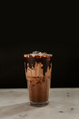 Iced chocolate, dark, cocoa, brown, milk mixed drinks. Menu for restaurant, cafe, ice, glass on black background.