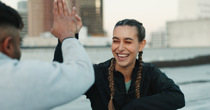 Happy couple, celebration or high five on rooftop for fitness exercise or workout together with pride or smile. Athletes, motivation or excited or man with woman, support or goal on building in city - Powered by Adobe