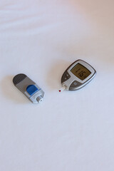 Woman's hands measuring blood glucose level using glucometer at home. Analysis of blood samples, concept of diabetes. Self-care and health