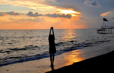 Portrait of a slender woman 30-35 years old in blue shorts and a yellow T-shirt, standing on the...