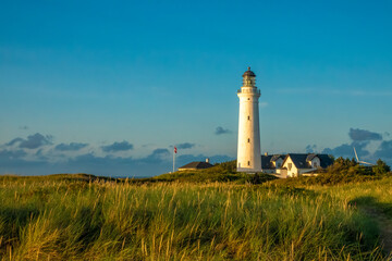 Iconic lighthouse of Hirsthals,  Jutland, Denmark. The setting is extraordinary, surrounded by cliffs, dunes, sandy beaches and historical WWII bunkers - obrazy, fototapety, plakaty