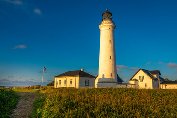 Fototapeta na wymiar Iconic lighthouse of Hirsthals, Jutland, Denmark. The setting is extraordinary, surrounded by cliffs, dunes, sandy beaches and historical WWII bunkers
