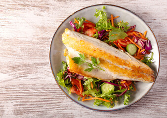 seabass fish fillet over salad