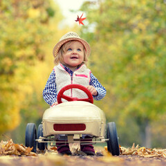 niedliches kleines Mädchen im Herbst im Tretauto