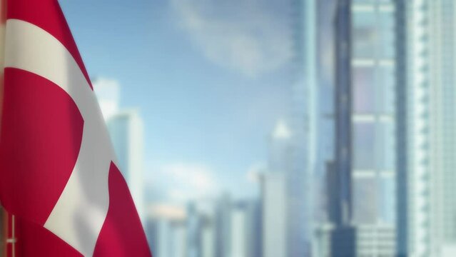 hanging Denmark flag on city backdrop with blue sky