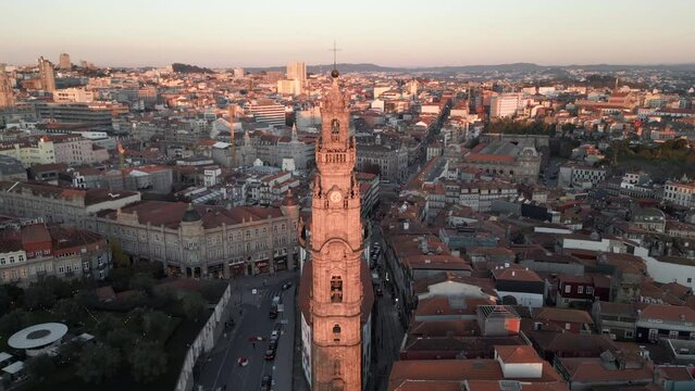 Aerial orbiting shot of historic landmark Clerigos Tower (Portuguese: Torre dos Clerigos) at sunset in Porto (Oporto), Portugal. 