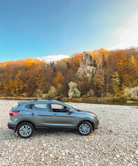 suv car at rocky beach near mountain river