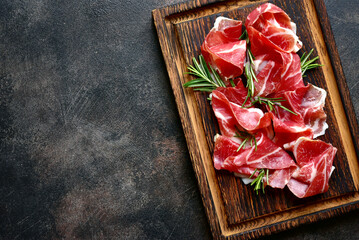 Slices of prosciutto di parma or jamon serrano (iberico) . Top view with copy space.