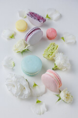 Fototapeta na wymiar Top view Set Beautiful colorful French macaroons and flowers. Spring Flat lay white background