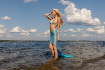 a girl in a mermaid dress on the riverbank, taken on a sunny day