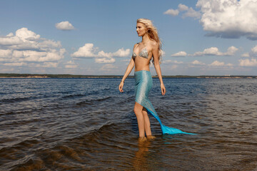 a girl in a mermaid dress on the riverbank, taken on a sunny day