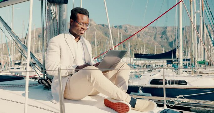 Boat, laptop and happy black man typing at sea to travel, vacation and holiday outdoor. Yacht, computer and African person at ocean port on internet, social media and reading email online to relax
