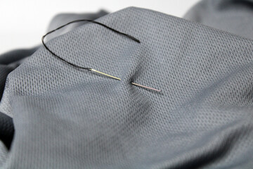 Black thread and needle on fabric