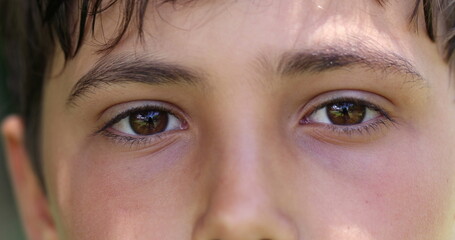 Boy closing and opening eyes close-up. Meditative Macro closeup of child eye looking to camera