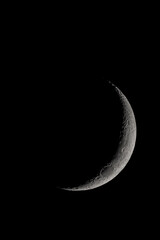 Crescent moon photographed with a telescope, where you can see the craters and the lunar surface, it will soon be a moon landing site