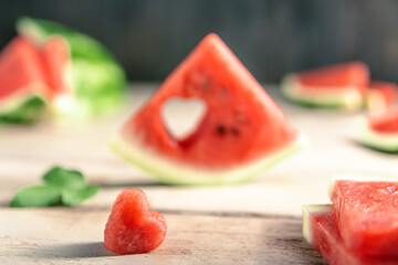 A cut piece of watermelon with a heart-shaped hole. Summer, joy, happiness, delicious food