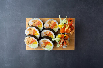 Gimbap with shrimp and various vegetables in a dark gray background