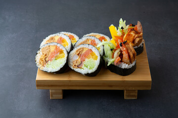 Gimbap with shrimp and various vegetables in a dark gray background