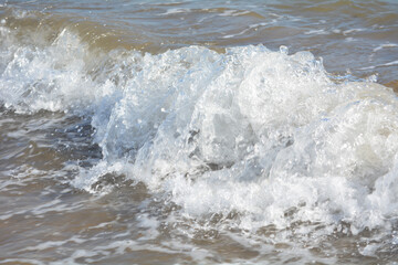 Ocean waves crashing on sandy beach. Sea waves breaking on shore. Nature splash on summer day. Sea...