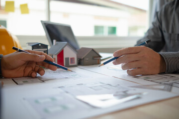Construction engineers discuss and exchange ideas with architects to improve house plans to meet customer needs. A concept for exchange of design ideas between construction engineers and architects.