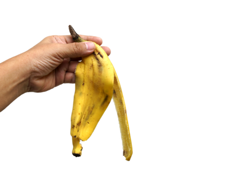 Banana peel in hand isolated on white background with clipping path, food and health concept, PNG.