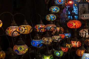 Many traditional colorful glass lanterns for sale at a local craft market. Selective focus, blurred background. Deira market in Dubai, UAE.