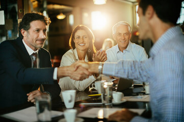 Diverse group of business coworkers having a meeting in a cafe or bar