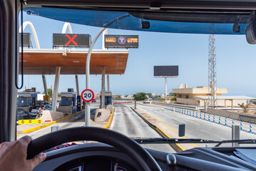 View from the driving position of a truck on the Via T lane at a tollbooth, specific for the passage of trucks and buses with electronic payment.Lane marked with a T in a blue circle.