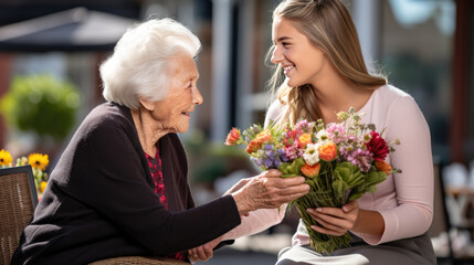 Granddaughter gives grandmother a bouquet of flowers for her birthday in honor of March 8