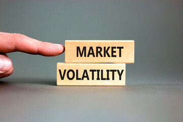Market volatility symbol. Concept words Market volatility on beautiful wooden blocks. Beautiful grey table grey background. Businessman hand. Business market volatility concept. Copy space.
