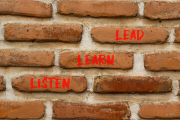 Listen learn lead symbol. Concept word Listen Learn Lead on beautiful red brown bricks. Beautiful red brown brickwall background. Business, education listen learn lead concept. Copy space.