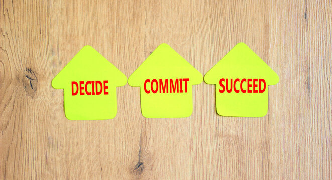 Decide commit succeed symbol. Concept word Decide Commit Succeed on beautiful yellow paper house. Beautiful wooden table wooden background. Business decide commit succeed concept. Copy space.
