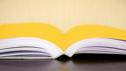 Close-up of an open book on a wooden table, copy space