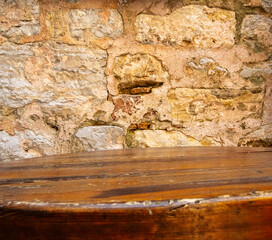 closeup of old wooden table and weathered brick wall