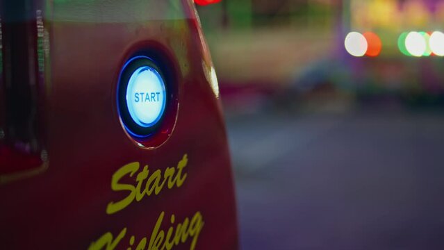 Hand pushing start button at arcade game machine closeup. Funfair girl playing