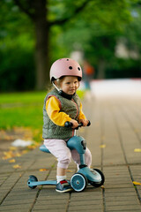 Happy girl riding a scooter in park