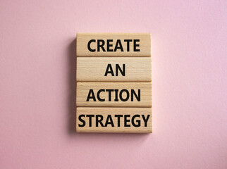 Create an action Strategy symbol. Wooden blocks with words Create an action Strategy. Beautiful pink background. Businessman hand. Business and Create an action Strategy concept. Copy space.
